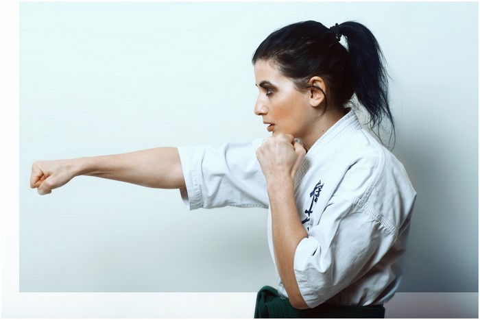 Brunette woman in Karate gi punching