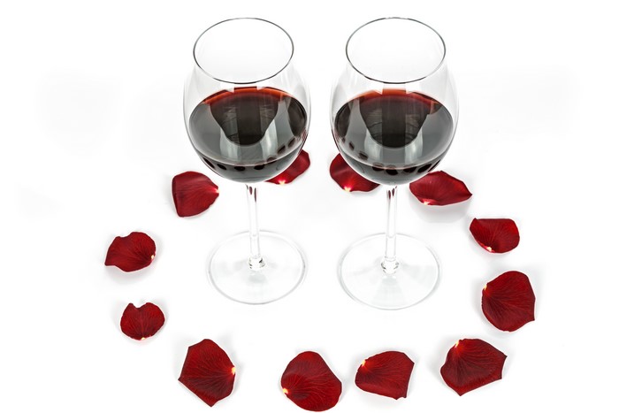 Two glasses of red wine with rose petals