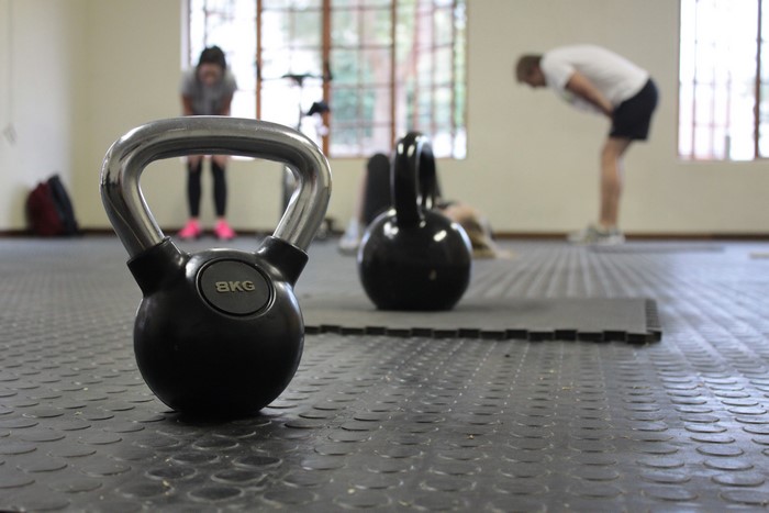 Gym with kettlebells and people exercising