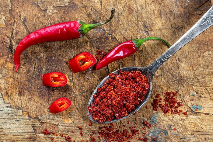 Red chili peppers and flakes on wood