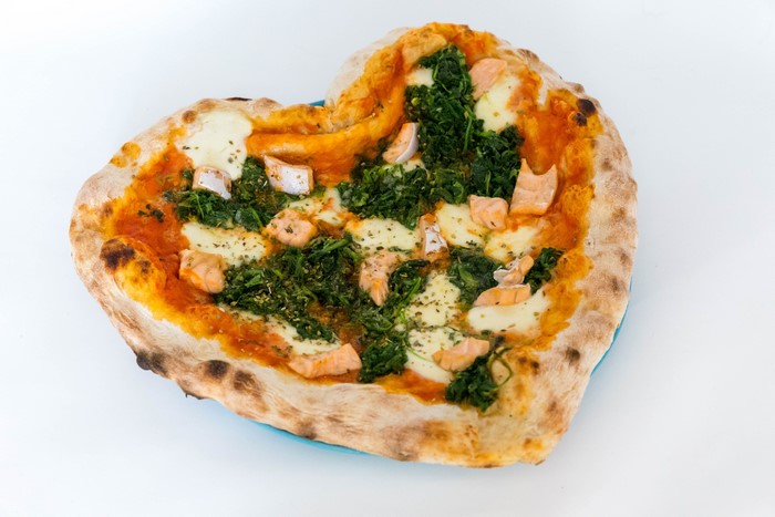 Heart-shaped pizza with salmon and spinach