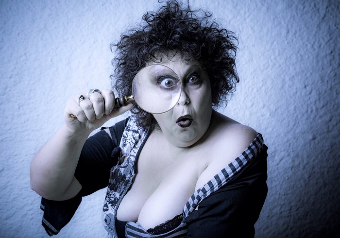 Woman looking through a magnifying glass