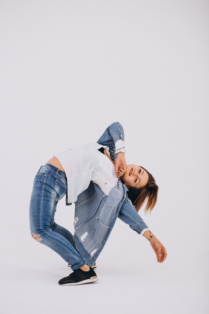 Woman in jeans and denim jacket dancing