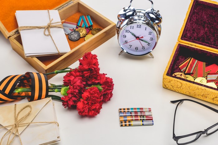 Victory Day composition with medals, carnations, and alarm clock