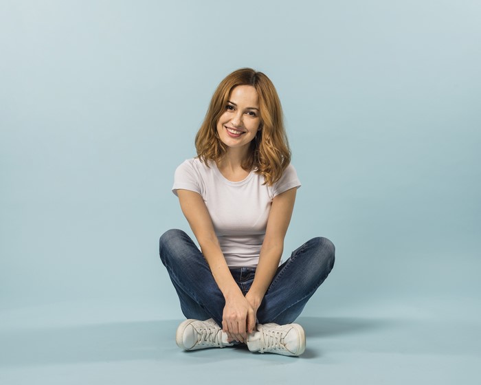 Woman with brown hair sitting cross-legged