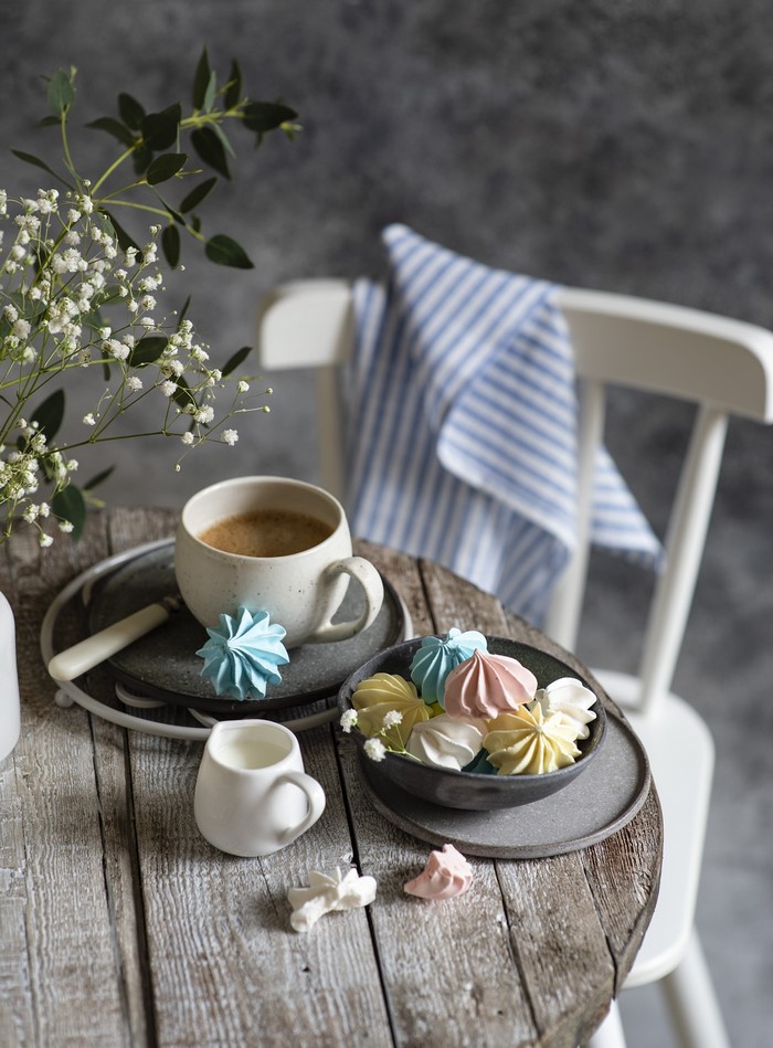 Coffee and colorful meringues on a wooden table