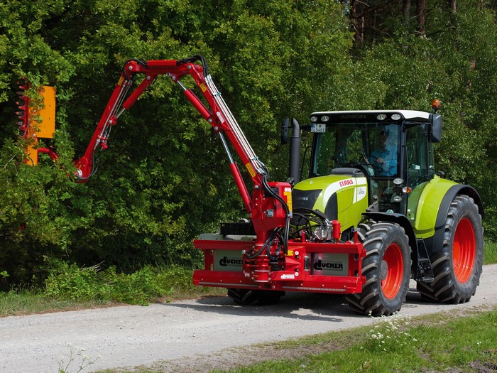 Claas Arion 540 tractor with hedge trimmer attachment