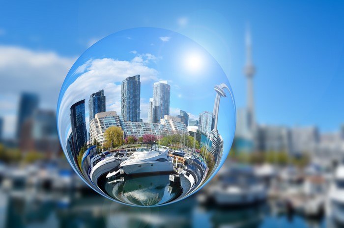 Cityscape reflected in a glass ball with yachts