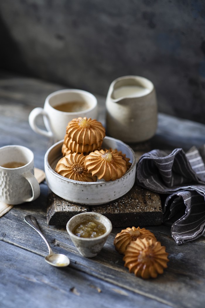 Cookies with coffee and jam on a wooden table