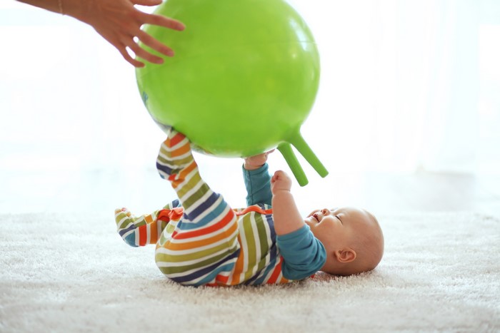 Baby playing with a green hopper ball
