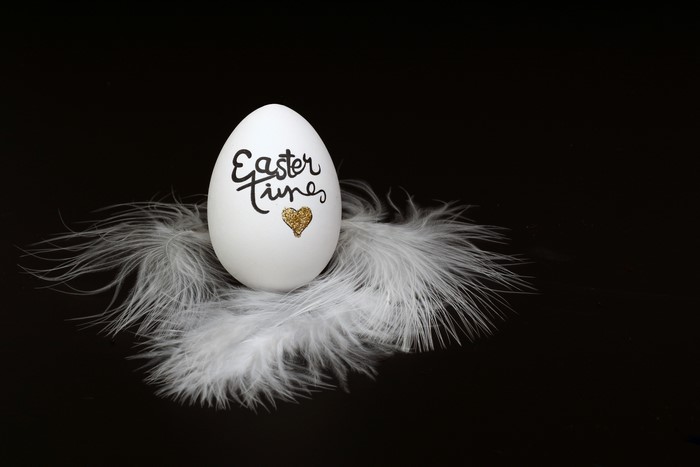 Easter egg with "Easter Times" text and gold heart on feathers