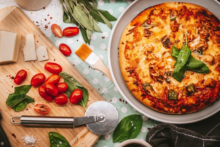 Pizza with Tomatoes, Cheese, and Cutting Board