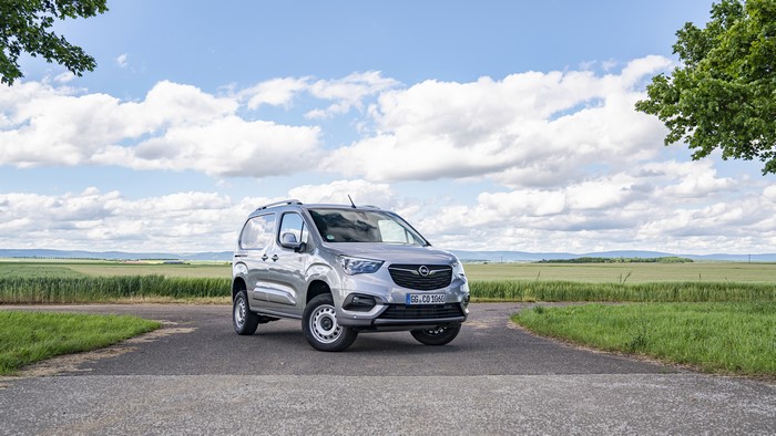 Grey Opel Minivan parked on a road with fields