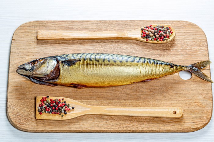 Smoked Mackerel with Peppercorns on a Cutting Board