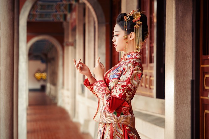 Asian woman in traditional red dress with jewelry