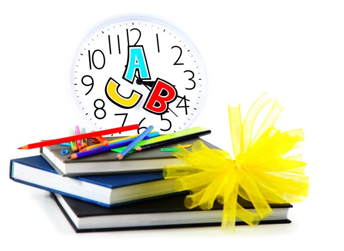Stack of books with school supplies and alphabet clock