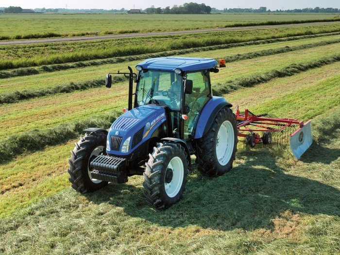 New Holland TD5.115 tractor raking hay in a field