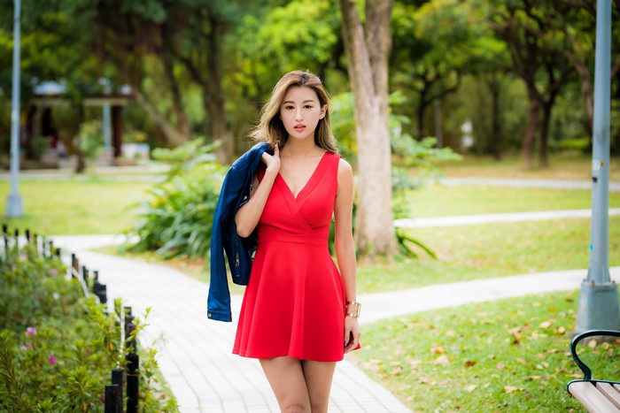 Asian woman in red dress holding jacket