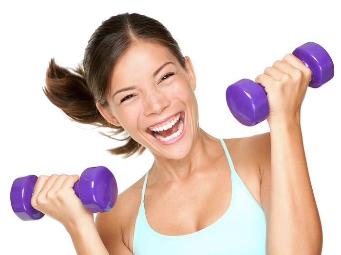Woman laughing while lifting dumbbells