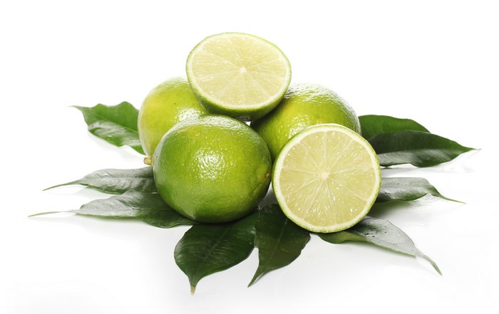 Limes with leaves on white background
