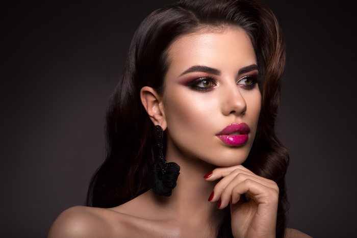 Model with dramatic makeup and black earrings