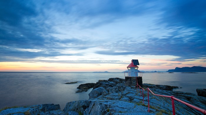 Lighthouse on a rocky coast at dusk in Norway