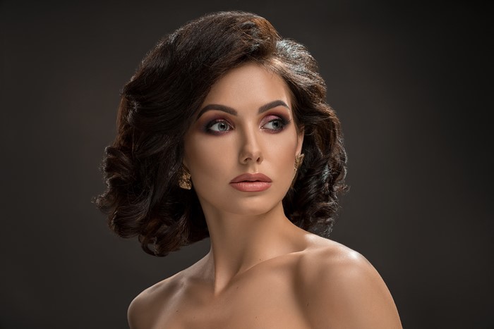 Brown haired woman with makeup and earrings