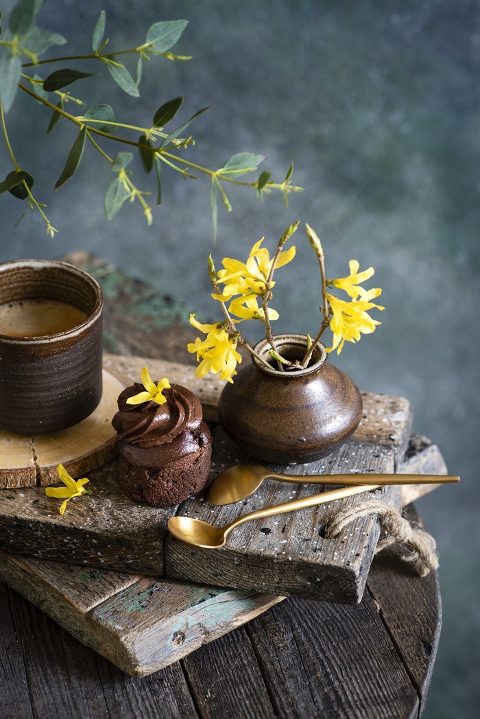 Chocolate cupcake with coffee and yellow flowers