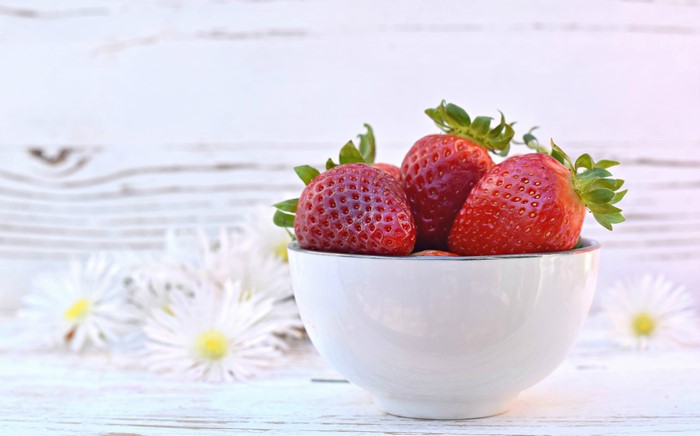 Strawberries in a bowl with flowers