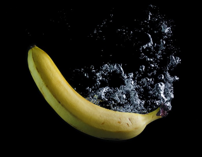 Banana splashing in water on black background