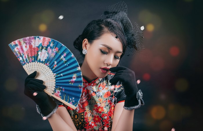 Asian woman in traditional dress holding a fan