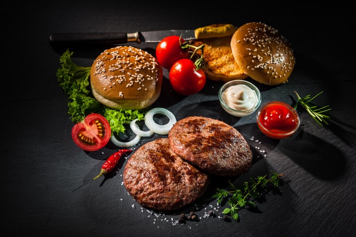 Burger Ingredients with Patties, Buns, Tomatoes, and Condiments