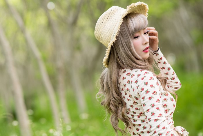 Asian woman wearing a straw hat and floral blouse