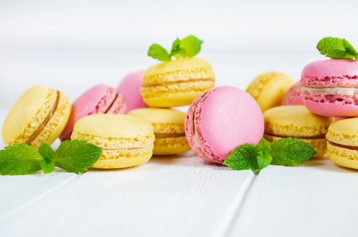 Pink and yellow macarons with mint leaves