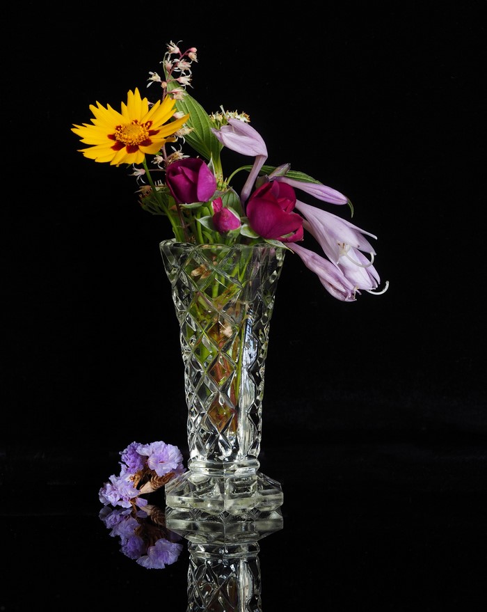 Bouquet of flowers in a crystal vase on a black background