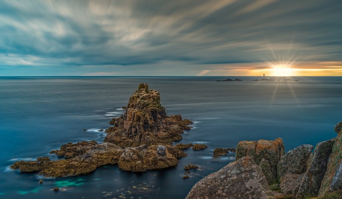 Sunset over the sea with rock formations in Cornwall, England