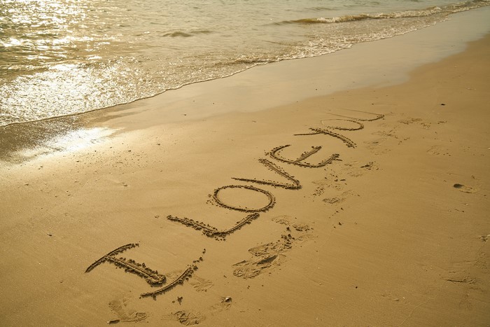 I love you written in the sand on a beach