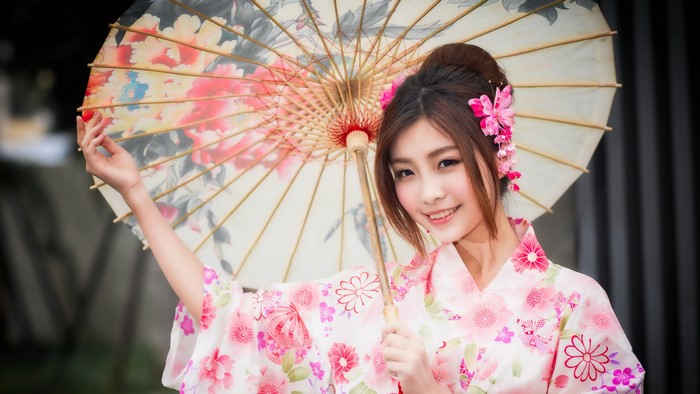 Asian woman in kimono holding a floral umbrella