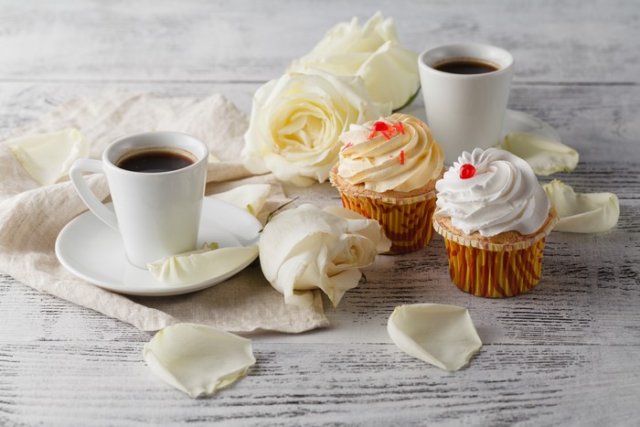 Coffee cups and cupcakes with roses