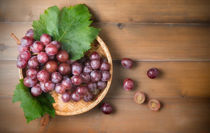 Red Grapes in a Wicker Basket with Leaves