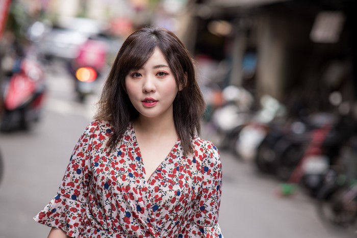 Asian woman in floral dress on street