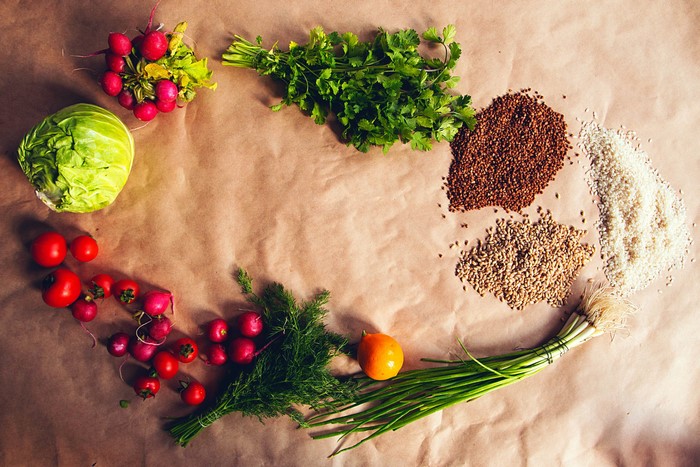 Vegetables and grains arranged on brown paper