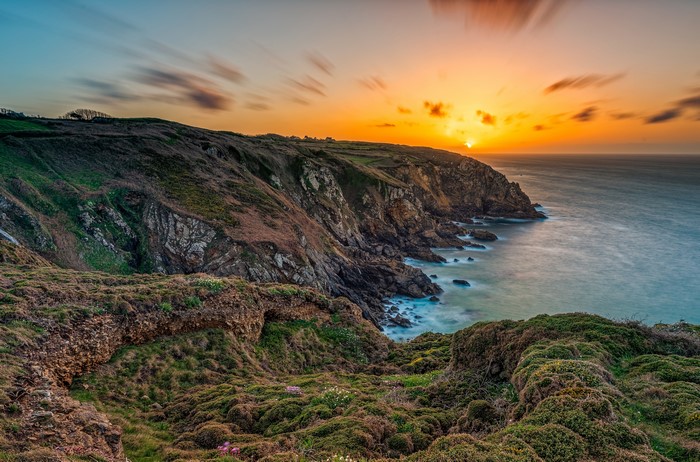 Sunset over a mossy cliff coast in Brittany, France