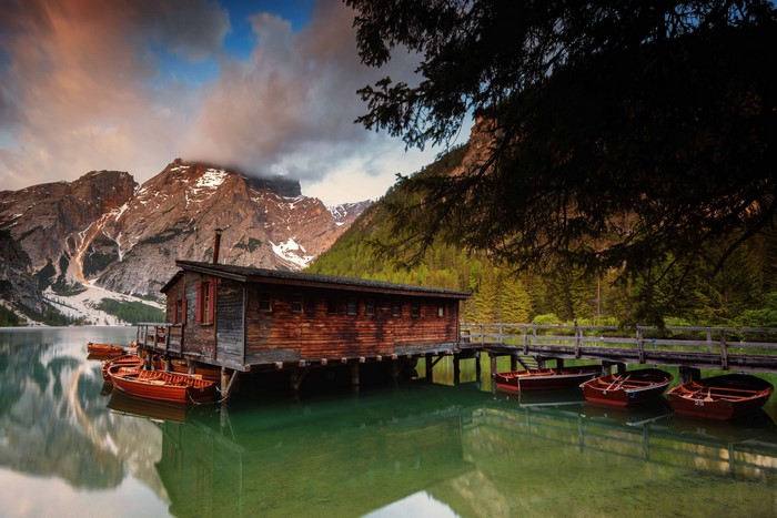 Wooden boathouse on Lake Braies with boats and mountains