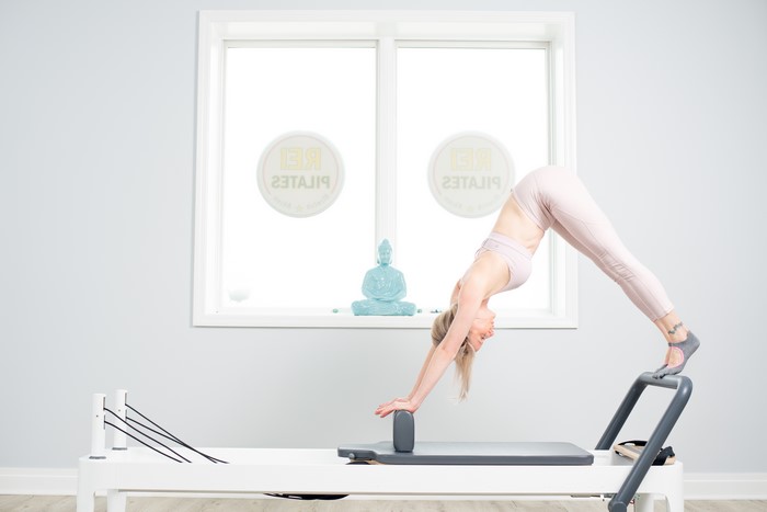 Woman doing Pilates on a reformer machine