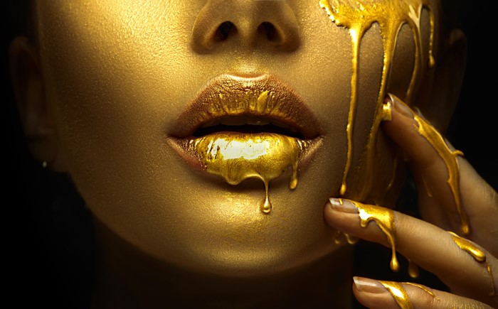 Gold makeup dripping on lips and face