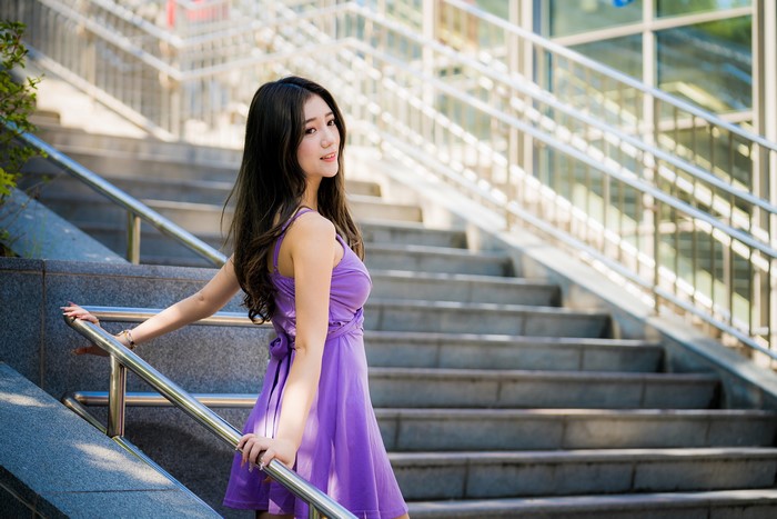 Asian woman in purple dress on stairs