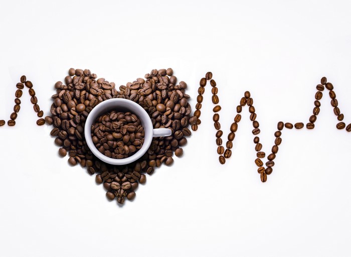 Coffee beans arranged in a heart shape with a heartbeat line
