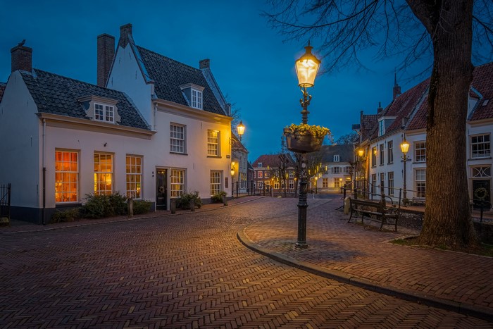 Street lights on a cobblestone street in Amersfoort, Netherlands at dusk