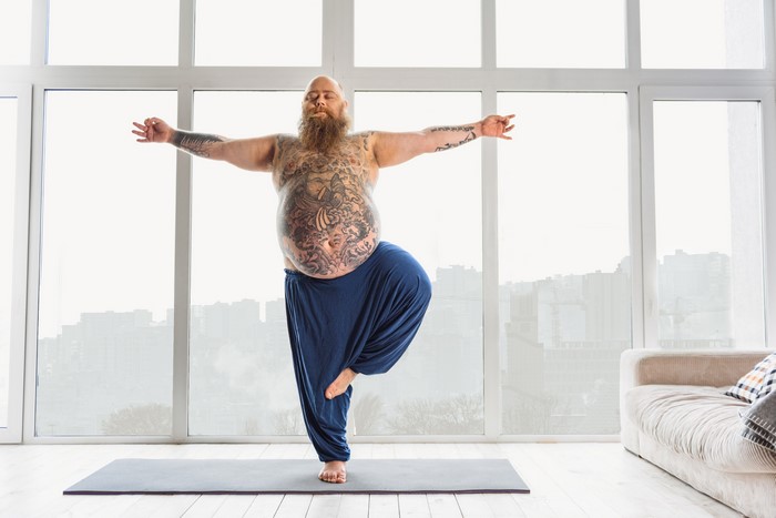 Man with tattoos practicing yoga